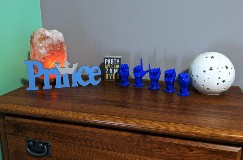 Letters "ELIAS" in blue with black letters on a dresser in nursery