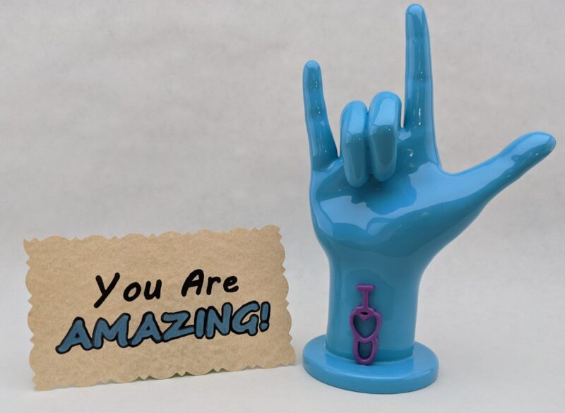 3d printed asl hand next to note
