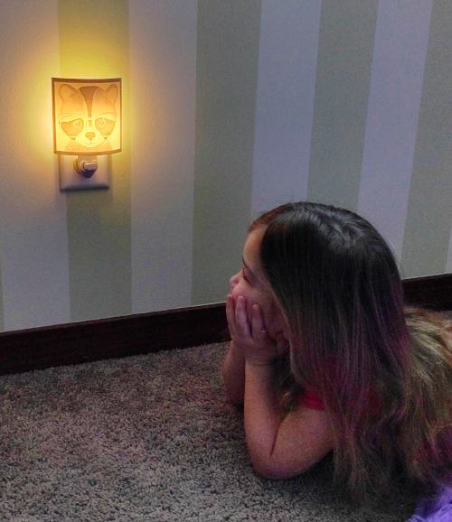 Girl looking at nightlight in bedroom